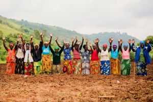 Women in a row with their hands in the air.